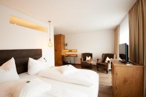 ein Hotelzimmer mit einem Bett und einem TV in der Unterkunft Hotel Schwaiger in Glonn