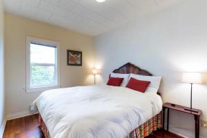 a bedroom with a large white bed with red pillows at Whale - Watcher's Perch in Depoe Bay