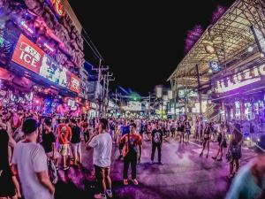 a crowd of people walking in a street at night at Sleep Box Patong Hostel in Patong Beach