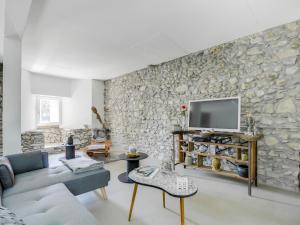 a living room with a stone wall at Le Loft de Rovorée in Yvoire