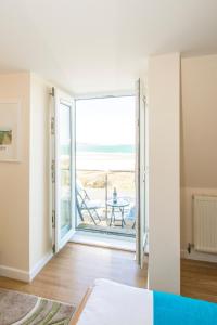 a bedroom with a door open to a patio with a table at The Penellen guest accommodation room only in Hayle