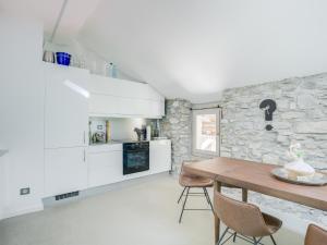 a kitchen with a table and a stone wall at Le Loft de Rovorée in Yvoire