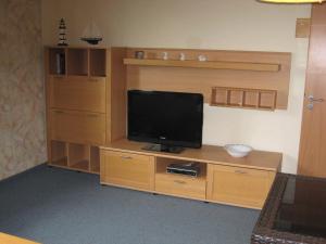 a room with a television on a wooden entertainment center at Haus Kuhlmann in Büsum