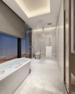 a white bathroom with a tub and a shower at Howard Johnson Zhujiang Hotel Chongqing in Chongqing