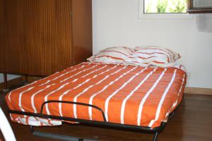 グリュイッサンにあるPALMIER SOLEIL 410のベッド1台(オレンジと白の掛け布団付)