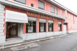 a store front of a red and white building at Albergo Ristorante Brera in Inveruno