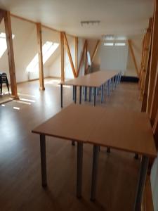 une rangée de tables dans une pièce avec une rangée de chaises dans l'établissement Aitiņlauvas, à Tīreļi