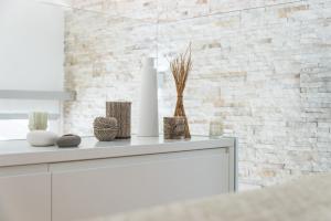 a white kitchen with a white brick wall at A modo nostro Design Home in Cagliari +13 photos