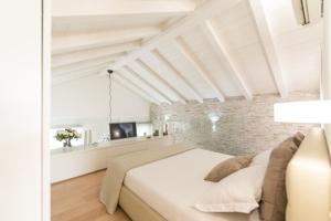 a bedroom with a white bed and a brick wall at A modo nostro Design Home in Cagliari