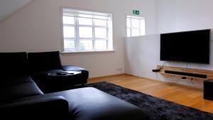 a living room with a couch and a flat screen tv at Askja Apartment in Húsavík