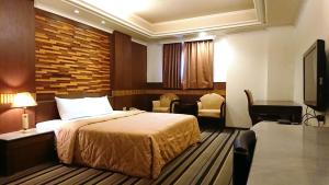 a hotel room with a bed and a flat screen tv at Ying Zhen Hotel in Taoyuan