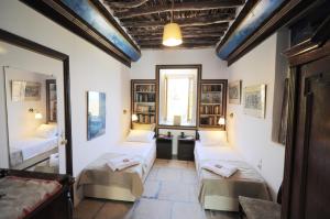a room with three beds and a window at Rallou House Hydra in Hydra