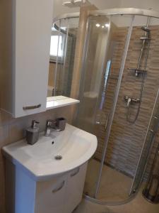 a bathroom with a white sink and a shower at Apartmani Luka in Grebaštica +28 photos