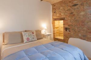 a bedroom with a bed and a stone wall at Casale delle Rondini in Notaresco