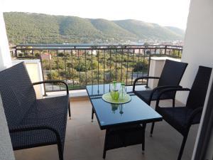 a table and chairs on a balcony with a view at Apartmani Luka in Grebaštica