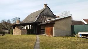 una casa vieja en un patio con un campo de hierba en Na Kopečku en Litomyšl