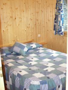 sypialnia z łóżkiem z niebiesko-białą kołdrą w obiekcie Casitas Cinco Castaños w mieście Candelario