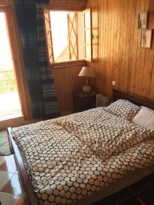 a bedroom with a large bed with a window at Chalet tizrag in Oukaïmeden