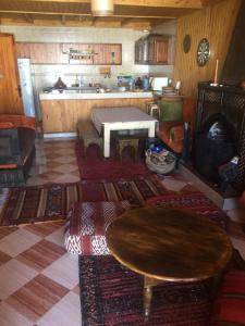 a living room with a table and a kitchen at Chalet tizrag in Oukaïmeden