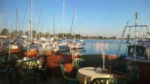 ein Yachthafen mit Tischen und Stühlen und Booten im Wasser in der Unterkunft Ferienwohnung Ostseeblick in Insel Poel + 15 Fotos