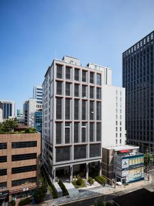 un grand bâtiment blanc au milieu d'une ville dans l'établissement Hotel NewV, à Séoul