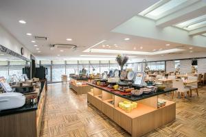 a restaurant with a buffet line with tables and chairs at Hotel Hokke Club Fukuoka in Fukuoka