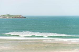 a surfer riding a wave in the ocean at The Penellen guest accommodation room only in Hayle