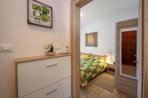 a bedroom with a bed and a dresser and a door at Apartment Polic in Šibenik