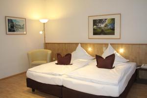a hotel room with a large white bed with two pillows at Hotel Die Tanne in Goslar