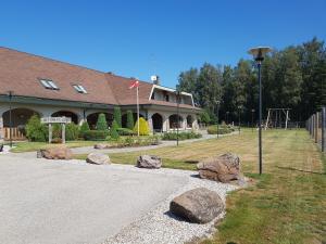 un edificio con rocas frente a un parque infantil en Aitiņlauvas, en Tīreļi