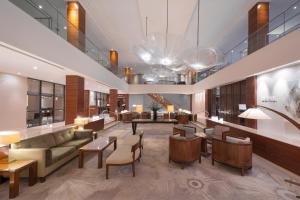 een lobby met een bank en tafels en stoelen bij Hotel Okura Amsterdam – The Leading Hotels of the World in Amsterdam
