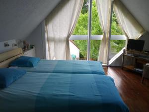 a bedroom with a blue bed and a large window at Albatros in Koksijde