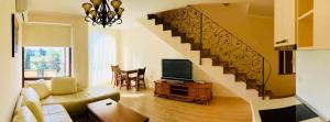 - un salon avec un escalier, un canapé et une télévision dans l'établissement Chateau Del Marina Penthouses, à Nessebar