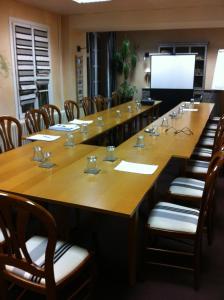 a large conference room with a large table and chairs at Logis Le Central in Coulon