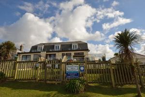 a house behind a wooden fence with a sign at The Penellen guest accommodation room only in Hayle