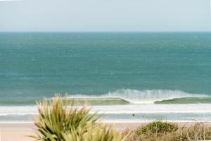 a beach with a large wave in the ocean at The Penellen guest accommodation room only in Hayle