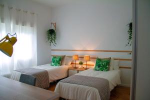 2 łóżka z zielonymi poduszkami w pokoju w obiekcie Real Beds Madrid w Madrycie
