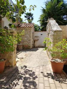 a courtyard with a stone wall and some plants at Apartment Sole in Poreč