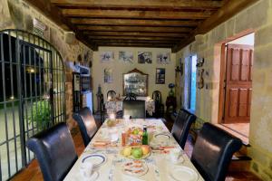 Posada Camino del Norte في جويميس: غرفة طعام مع طاولة طويلة مع كراسي وطاولة