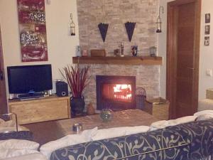 sala de estar con chimenea y sofá en Casa Rural Lago Bolarque en Albalate de Zorita