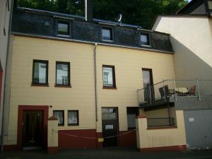 een wit gebouw met een rode deur en een balkon bij Ferienhaus Burgeiche in Bernkastel-Kues