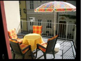 een tafel en stoelen op een balkon met een parasol bij Ferienhaus Burgeiche in Bernkastel-Kues