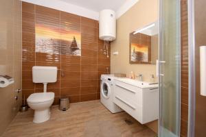 a bathroom with a toilet and a sink and a washing machine at Apartment Polic in Šibenik +36 photos