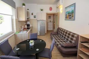 a kitchen and a living room with a table and a couch at Apartment Polic in Šibenik