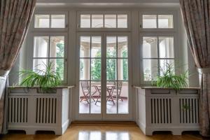 a room with doors and windows with plants at Aparthotel Villa Freisleben in Dresden