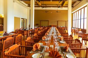 comedor grande con mesas y sillas largas en Grand Beach, en Wadduwa
