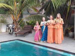 a group of girls standing next to a swimming pool at Karl Holiday Bungalow in Kalutara