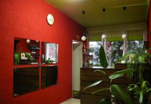 a room with a red wall with a clock on it at Pokoje Goscinne Koral in Radomsko