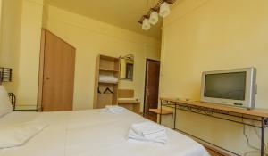 ein Hotelzimmer mit zwei Betten und einem Fernseher in der Unterkunft Pensiunea Tranzit in Satu Mare