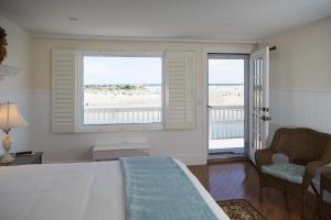 a room with a bed and two windows with a view of the beach at Marginal Way House in Ogunquit